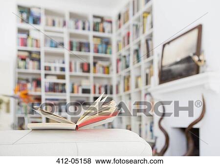 Open book on arm of sofa in living room View Large Photo Image Stock Photo - Open book on arm of sofa in living room. Fotosearch