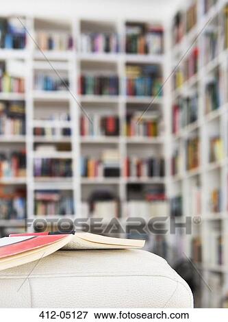 Stock Photo - Open book on sofa in living room. Fotosearch