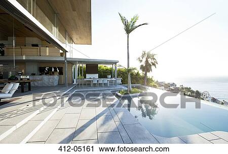 Stock Image - Palm tree in infinity pool. Fotosearch