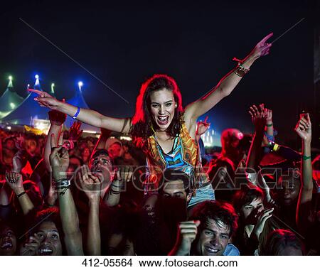Cheering woman on man's shoulders at music festival View Large Photo Image Picture - Cheering woman on man's shoulders at music festival. Fotosearch