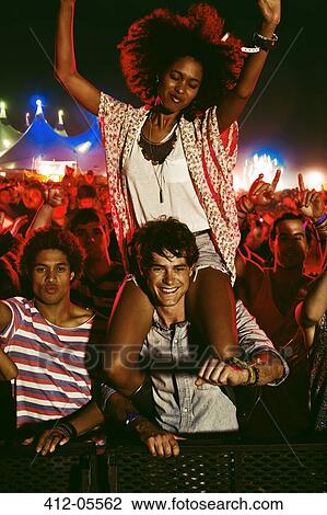 Cheering woman on man's shoulders at music festival View Large Photo Image Stock Image - Cheering woman on man's shoulders at music festival. Fotosearch