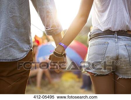 Couple holding hands near tents at music festival View Large Photo Image Stock Photography - Couple holding hands near tents at music festival. Fotosearch