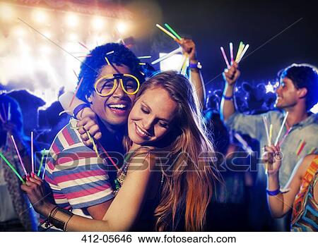 Couple with glow sticks hugging at music festival View Large Photo Image Stock Photograph - Couple with glow sticks hugging at music festival. Fotosearch