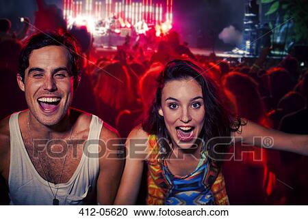Enthusiastic couple cheering at music festival View Large Photo Image Stock Image - Enthusiastic couple cheering at music festival. Fotosearch