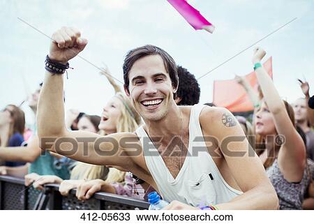 Enthusiastic man cheering at music festival View Large Photo Image Stock Image - Enthusiastic man cheering at music festival. Fotosearch