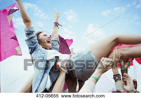 Enthusiastic woman crowd surfing at music festival View Large Photo Image Stock Photography - Enthusiastic woman crowd surfing at music festival. Fotosearch
