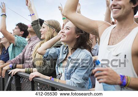 Stock Image - Fans cheering at music festival. Fotosearch