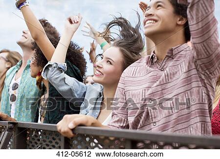 Stock Image - Fans cheering at music festival. Fotosearch