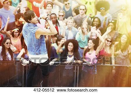 Fans cheering for singer performing on stage at music festival View Large Photo Image Stock Image - Fans cheering for singer performing on stage at music festival. Fotosearch