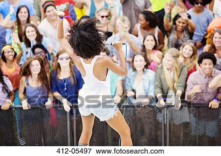 Fans watching performer sing at music festival View Large Photo Image Stock Photo - Fans watching performer sing at music festival. Fotosearch
