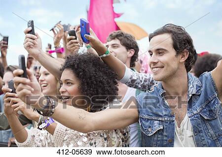 Fans with camera phones cheering at music festival View Large Photo Image Stock Photo - Fans with camera phones cheering at music festival. Fotosearch