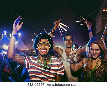 Fans with glow sticks cheering at music festival View Large Photo Image Stock Photo - Fans with glow sticks cheering at music festival. Fotosearch