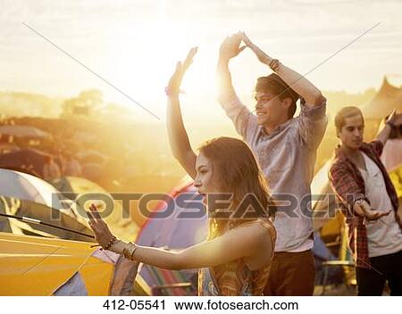 Friends dancing outside tents at music festival View Large Photo Image Stock Image - Friends dancing outside tents at music festival. Fotosearch