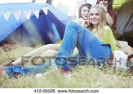 Friends relaxing outside tents at music festival View Large Photo Image Stock Photograph - Friends relaxing outside tents at music festival. Fotosearch