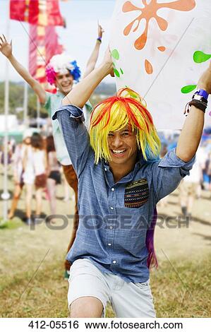 Playful men cheering in wigs at music festival View Large Photo Image Stock Photograph - Playful men cheering in wigs at music festival. Fotosearch
