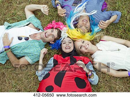 Portrait of friends in costumes laying in grass at music festival View Large Photo Image Stock Image - Portrait of friends in costumes laying in grass at music festival. Fotosearch
