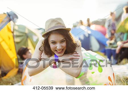 Portrait of smiling woman leaning on inflatable chair outside tents at music festival View Large Photo Image Stock Photo - Portrait of smiling woman leaning on inflatable chair outside tents at music festival. Fotosearch
