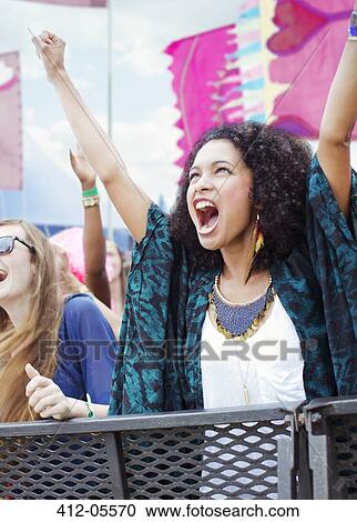 Stock Image - Woman cheering at music festival. Fotosearch