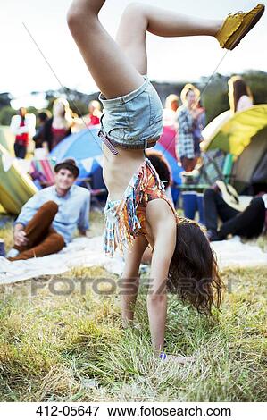 Woman doing handstand outside tents at music festival View Large Photo Image Stock Photo - Woman doing handstand outside tents at music festival. Fotosearch