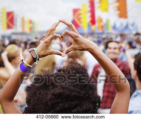 Woman forming heart-shape with hands at music festival View Large Photo Image Stock Image - Woman forming heart-shape with hands at music festival. Fotosearch
