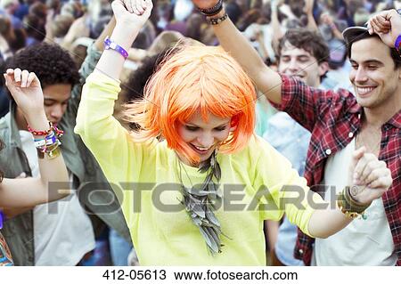 Stock Image - Woman in wig dancing at music festival. Fotosearch