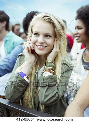 Picture - Woman talking on cell phone at music festival. Fotosearch