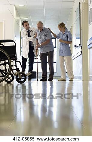 Doctor and nurse helping older patient walk in hospital View Large Photo Image Stock Photography - Doctor and nurse helping older patient walk in hospital. Fotosearch