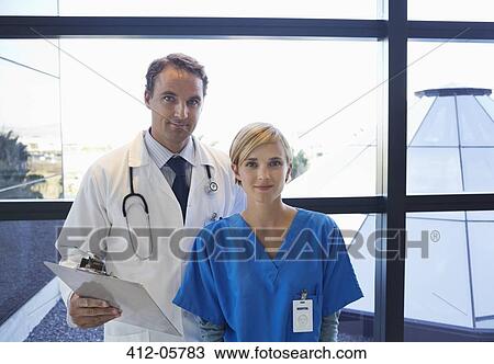 Doctor and nurse standing by window View Large Photo Image Stock Image - Doctor and nurse standing by window. Fotosearch