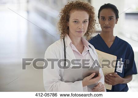 Doctor and nurse standing in hallway View Large Photo Image Stock Photograph - Doctor and nurse standing in hallway. Fotosearch