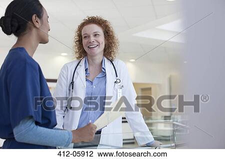 Doctor and nurse talking in hospital hallway View Large Photo Image Stock Image - Doctor and nurse talking in hospital hallway. Fotosearch
