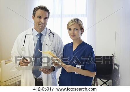 Stock Photo - Doctor and nurse talking in hospital room. Fotosearch