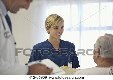 Stock Photo - Doctor and nurse talking to older patient in hospital room. Fotosearch