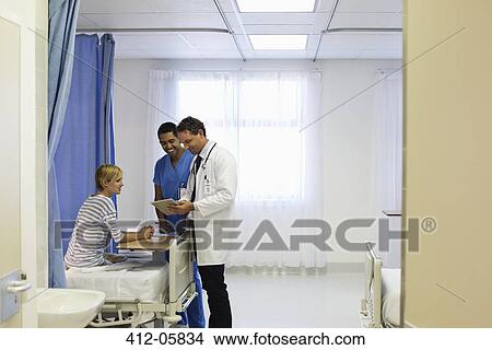 Doctor and nurse talking to patient in hospital room View Large Photo Image Picture - Doctor and nurse talking to patient in hospital room. Fotosearch