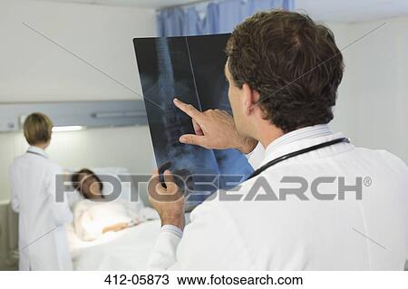 Doctor examining x-rays in hospital room View Large Photo Image Stock Image - Doctor examining x-rays in hospital room. Fotosearch