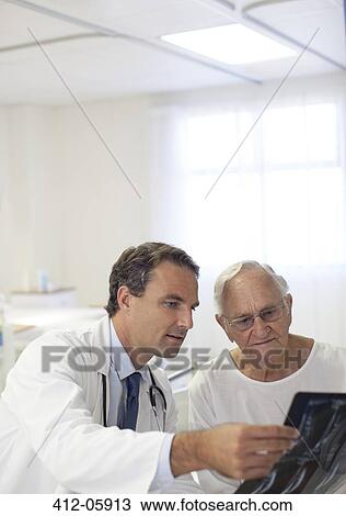 Doctor showing x-rays to older patient in hospital room View Large Photo Image Stock Image - Doctor showing x-rays to older patient in hospital room. Fotosearch