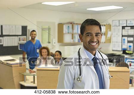 Doctor smiling in hospital hallway View Large Photo Image Stock Photo - Doctor smiling in hospital hallway. Fotosearch