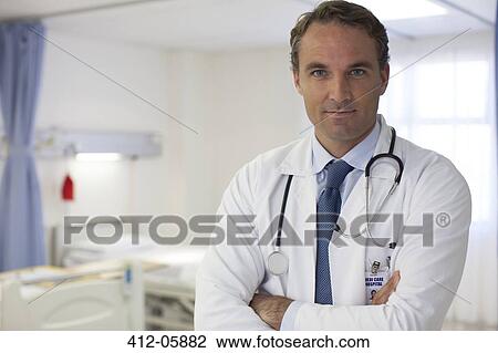 Stock Image - Doctor standing in hospital room. Fotosearch