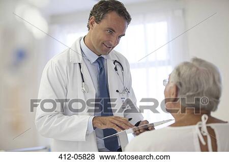 Doctor talking to older patient in hospital View Large Photo Image Stock Photo - Doctor talking to older patient in hospital. Fotosearch