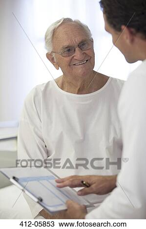 Doctor talking with older patient in hospital room View Large Photo Image Stock Image - Doctor talking with older patient in hospital room. Fotosearch