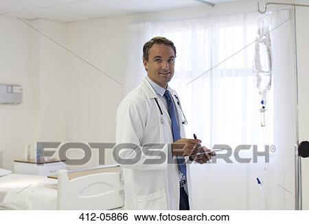 Doctor writing on clipboard in hospital View Large Photo Image Stock Photograph - Doctor writing on clipboard in hospital. Fotosearch