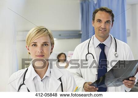 Doctors standing in hospital room View Large Photo Image Stock Photo - Doctors standing in hospital room. Fotosearch
