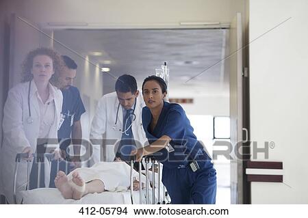 Hospital staff rushing patient to operating room View Large Photo Image Picture - Hospital staff rushing patient to operating room. Fotosearch