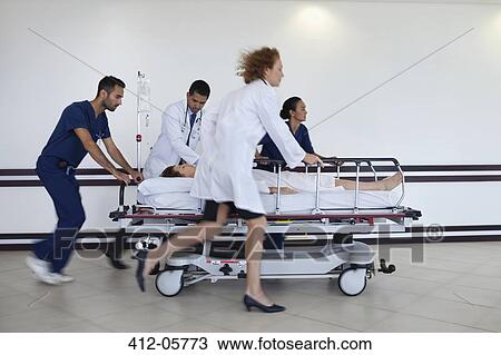 Hospital staff rushing patient to operating room View Large Photo Image Stock Image - Hospital staff rushing patient to operating room. Fotosearch