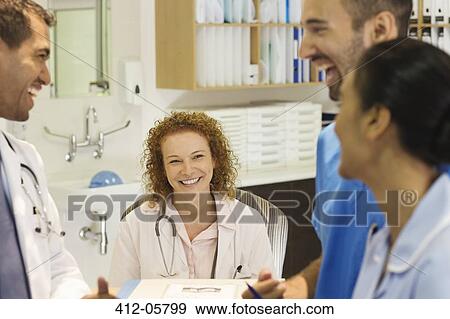 Stock Photo - Hospital staff talking at desk. Fotosearch