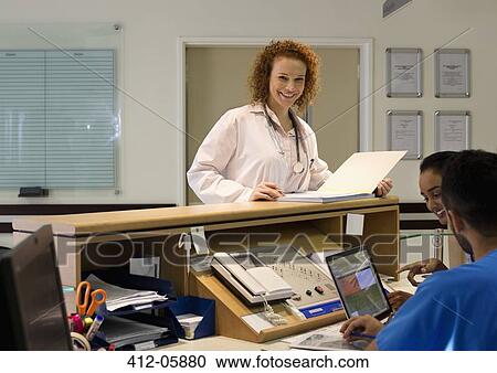 Hospital staff talking at front desk View Large Photo Image Stock Image - Hospital staff talking at front desk. Fotosearch
