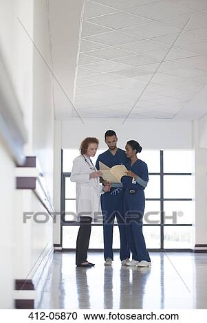 Stock Image - Hospital staff talking in hallway. Fotosearch
