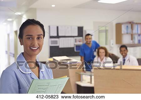 Nurse smiling in hospital hallway View Large Photo Image Stock Image - Nurse smiling in hospital hallway. Fotosearch