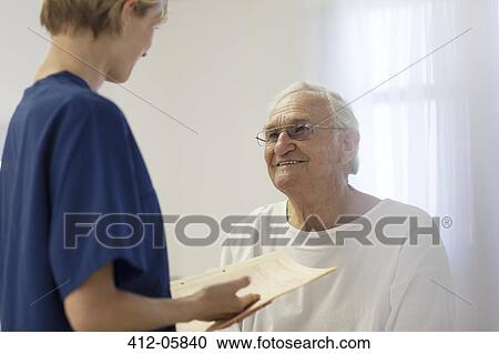 Nurse talking to older patient in hospital room View Large Photo Image Stock Image - Nurse talking to older patient in hospital room. Fotosearch