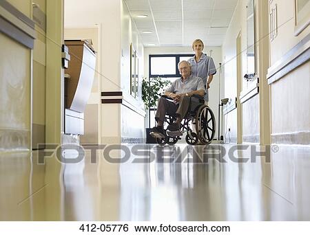 Nurse wheeling older patient in hospital View Large Photo Image Stock Photograph - Nurse wheeling older patient in hospital. Fotosearch