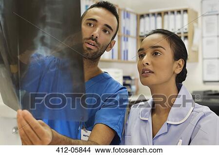 Picture - Nurses examining x-rays in hospital. Fotosearch